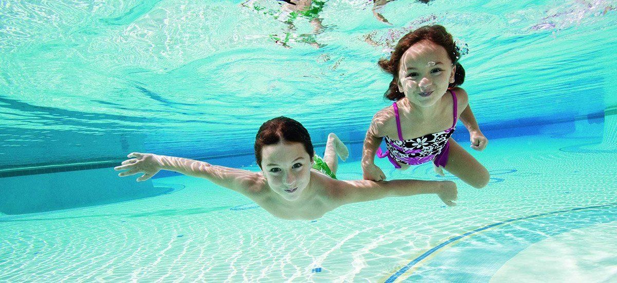 Kids swim in pool underwater