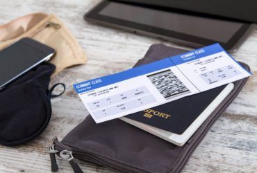 A boarding pass is sitting on top of a passport.