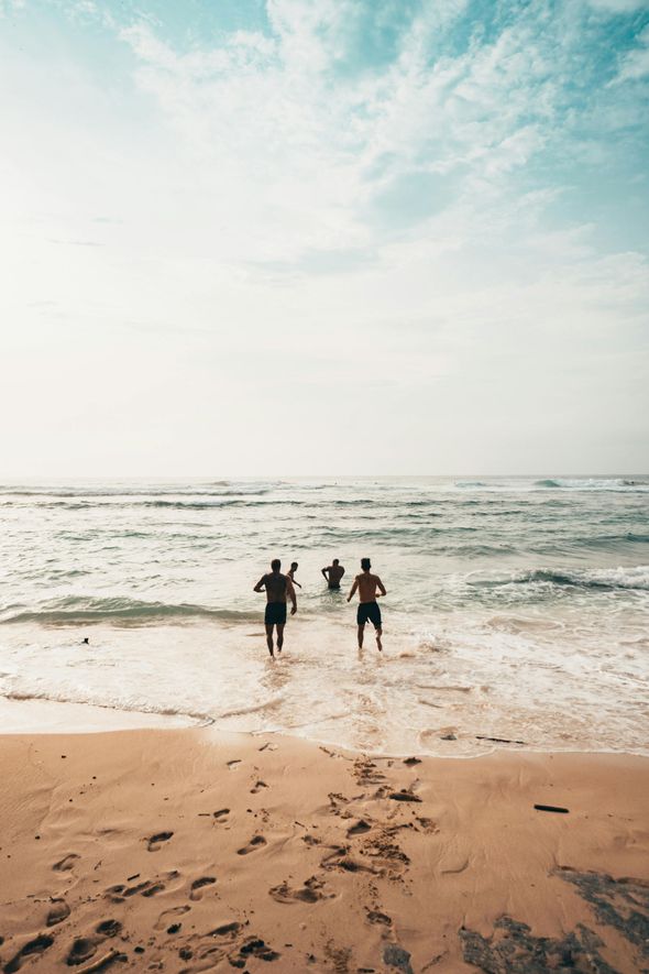 people running into the ocean