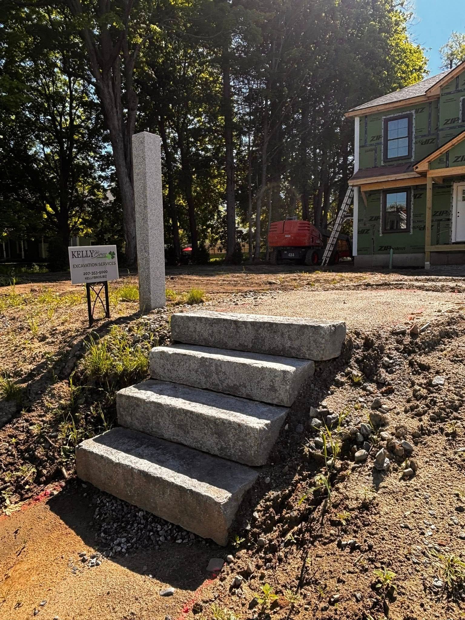 Concrete steps leading to a small house with a red cart in a wooded yard