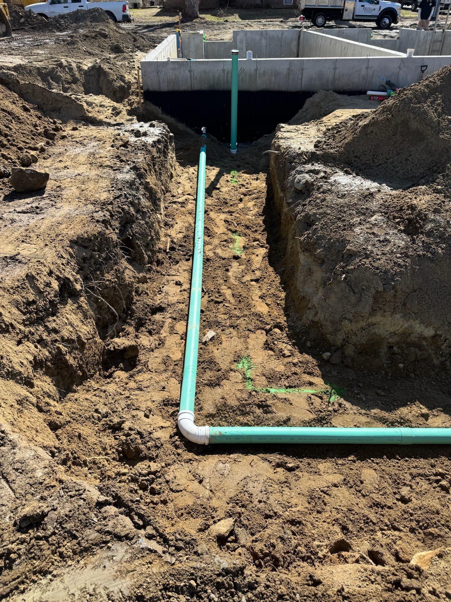 Overhead view of an excavator clearing dirt in a tan construction site
