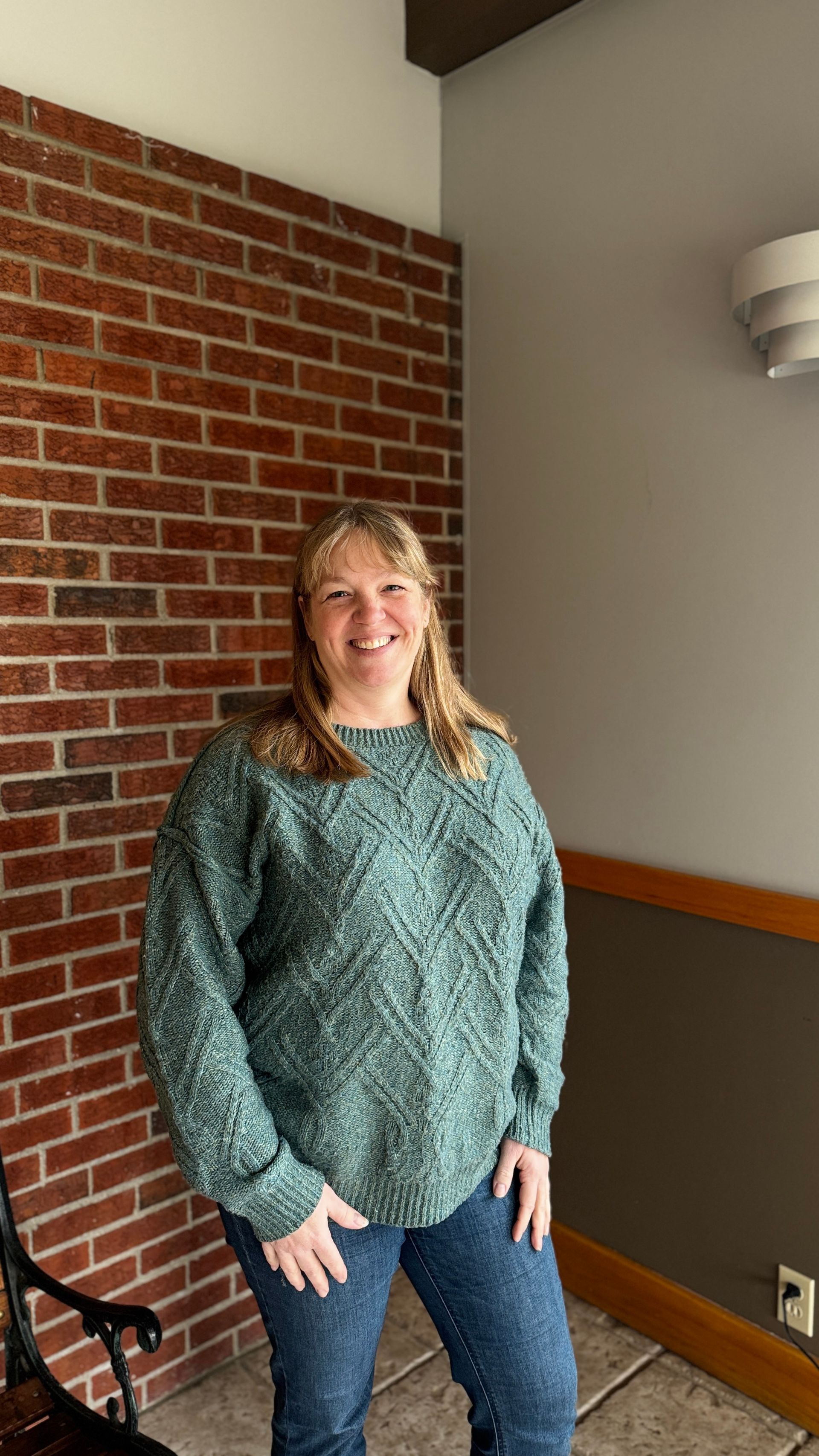 A woman in a pink shirt is smiling for the camera
