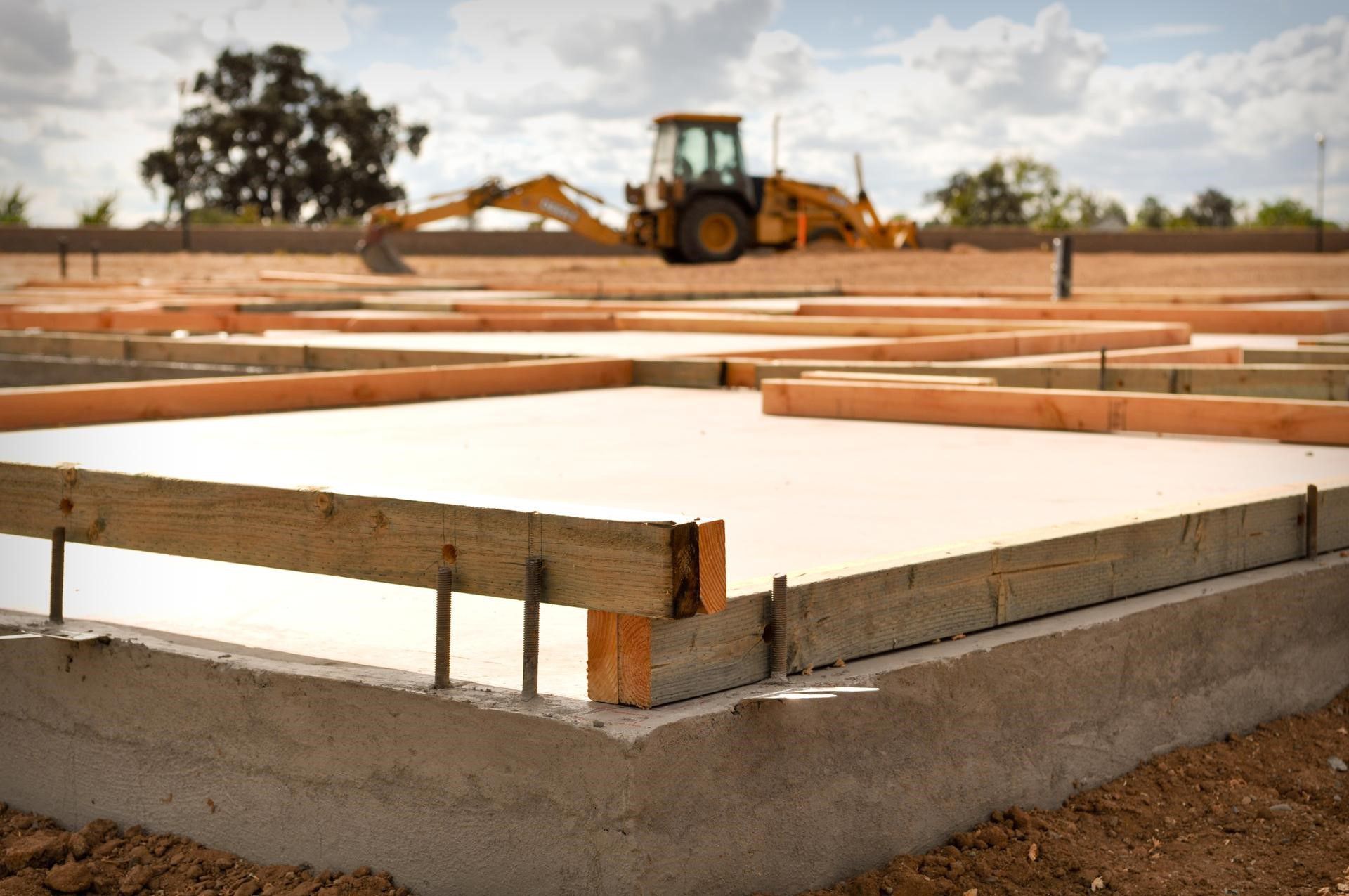 A construction site with a tractor in the background.