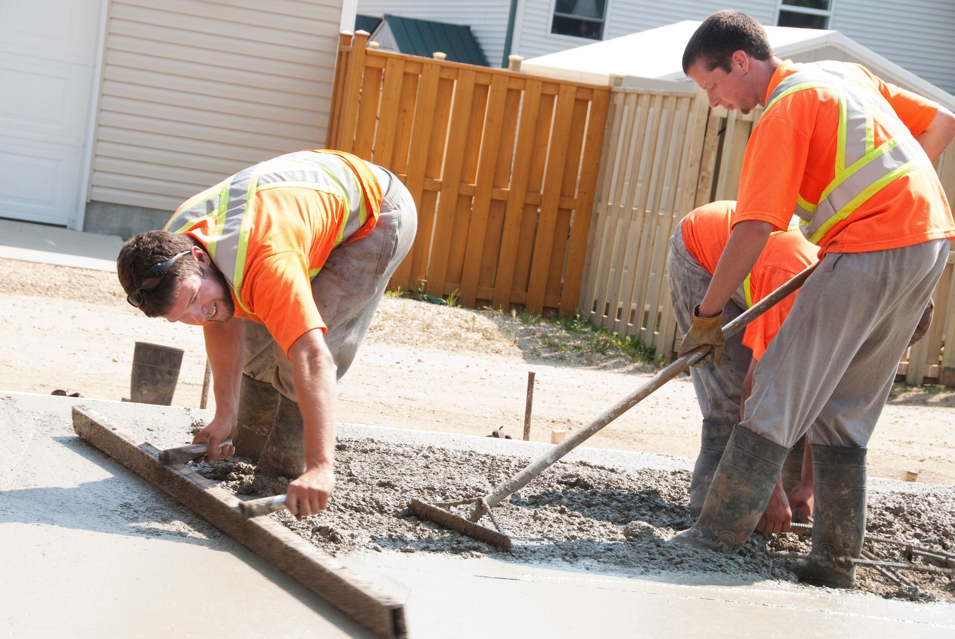 Concrete repair crew pouring fresh mix for a long-lasting residential driveway installation.