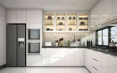 Modern white kitchen with refrigerator, ovens, cabinets, and a window.