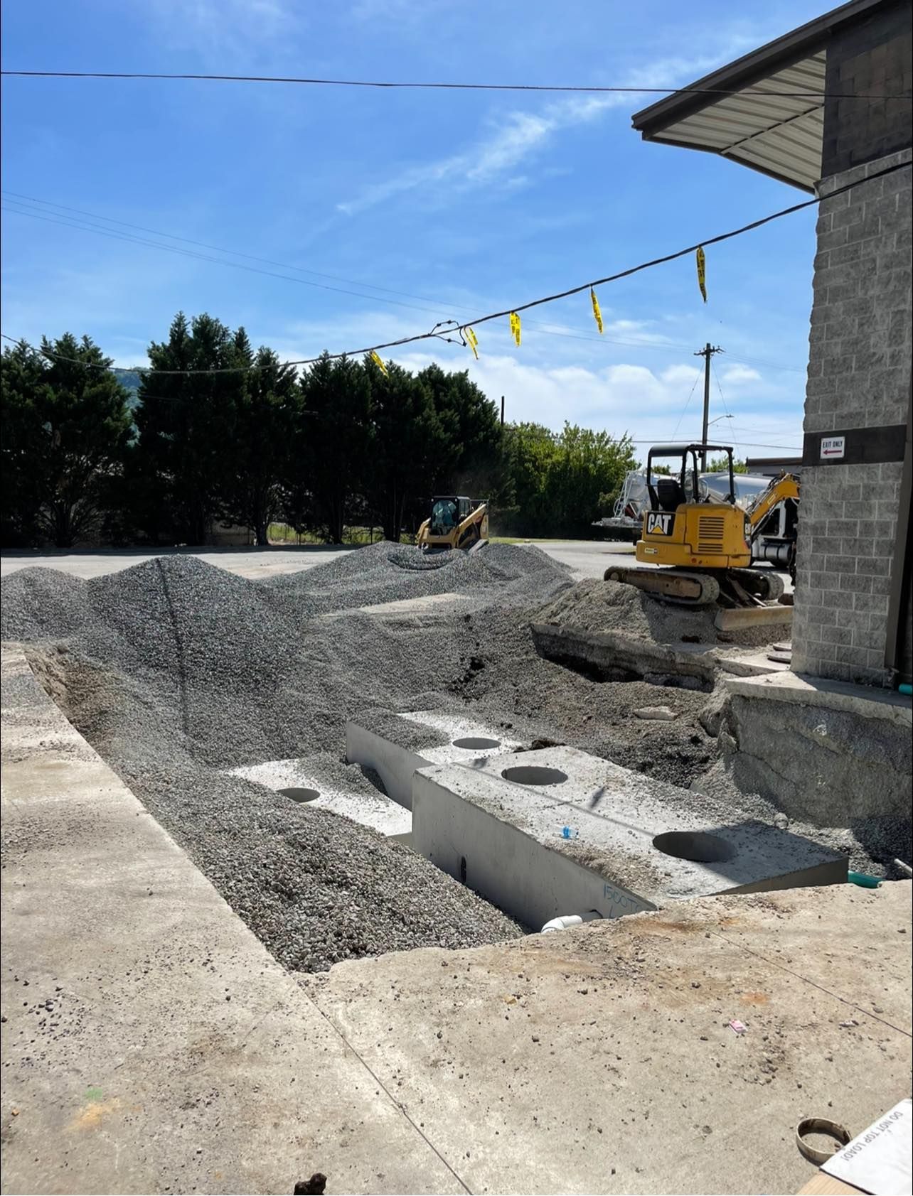 A construction site with a yellow excavator in the foreground