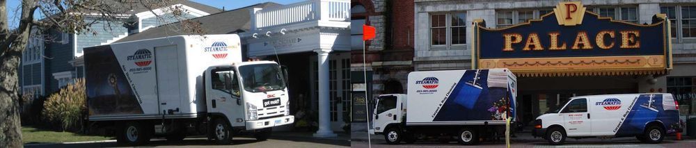 Moving trucks parked outside a building and a theater. The Palace sign is visible.