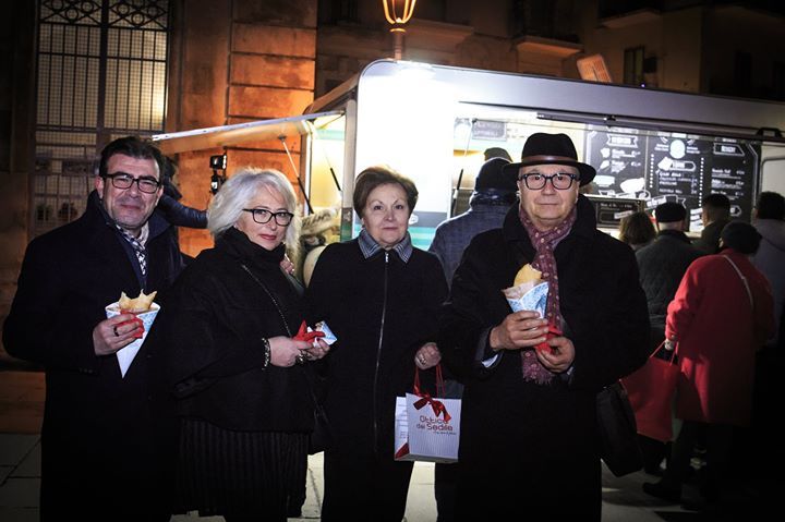 Un gruppo di persone in piedi davanti a un camioncino di cibo