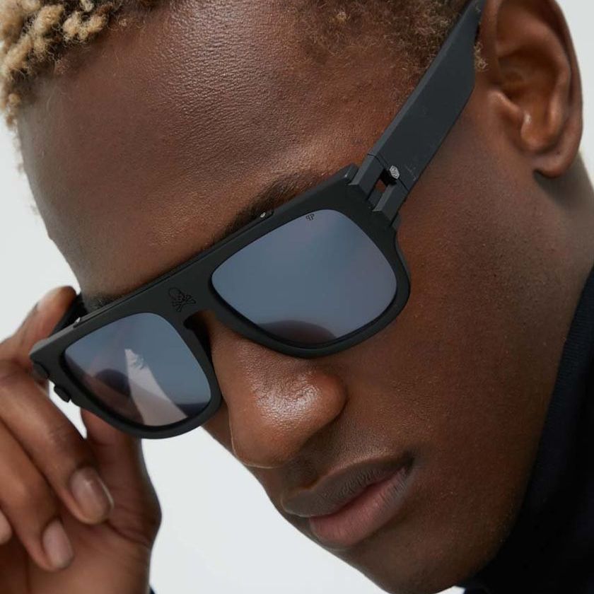 Un primo piano di un uomo che indossa occhiali da sole neri