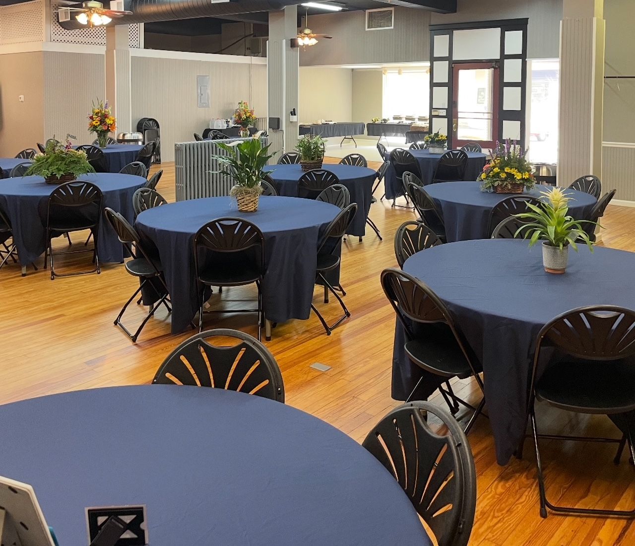 A large room with blue tables and chairs