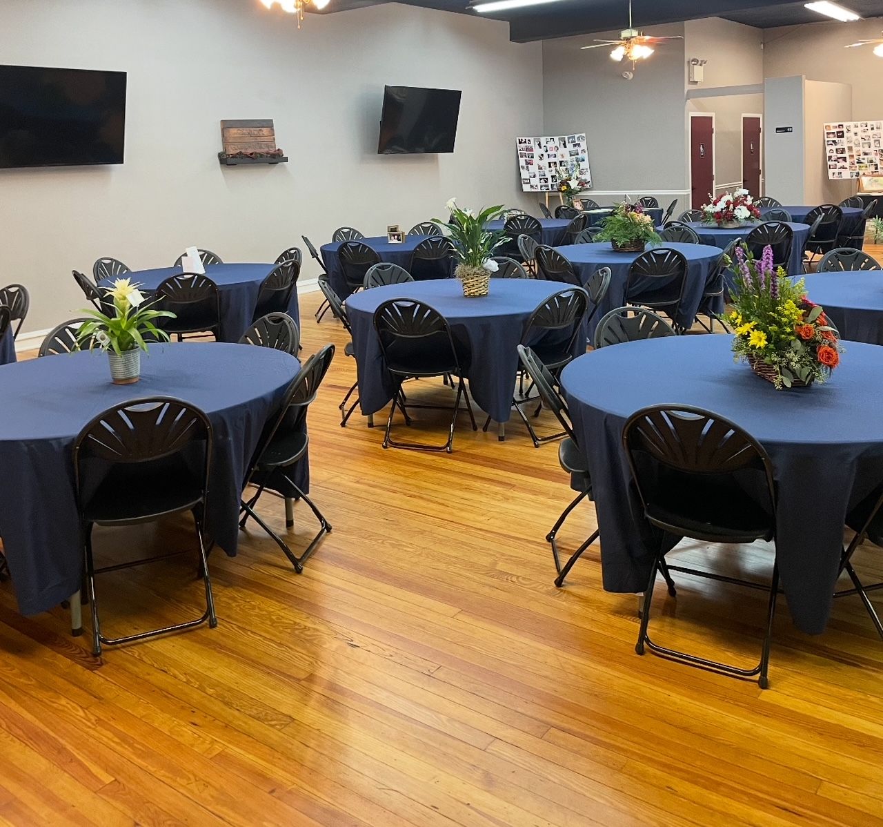 A room filled with tables and chairs with blue tables cloths