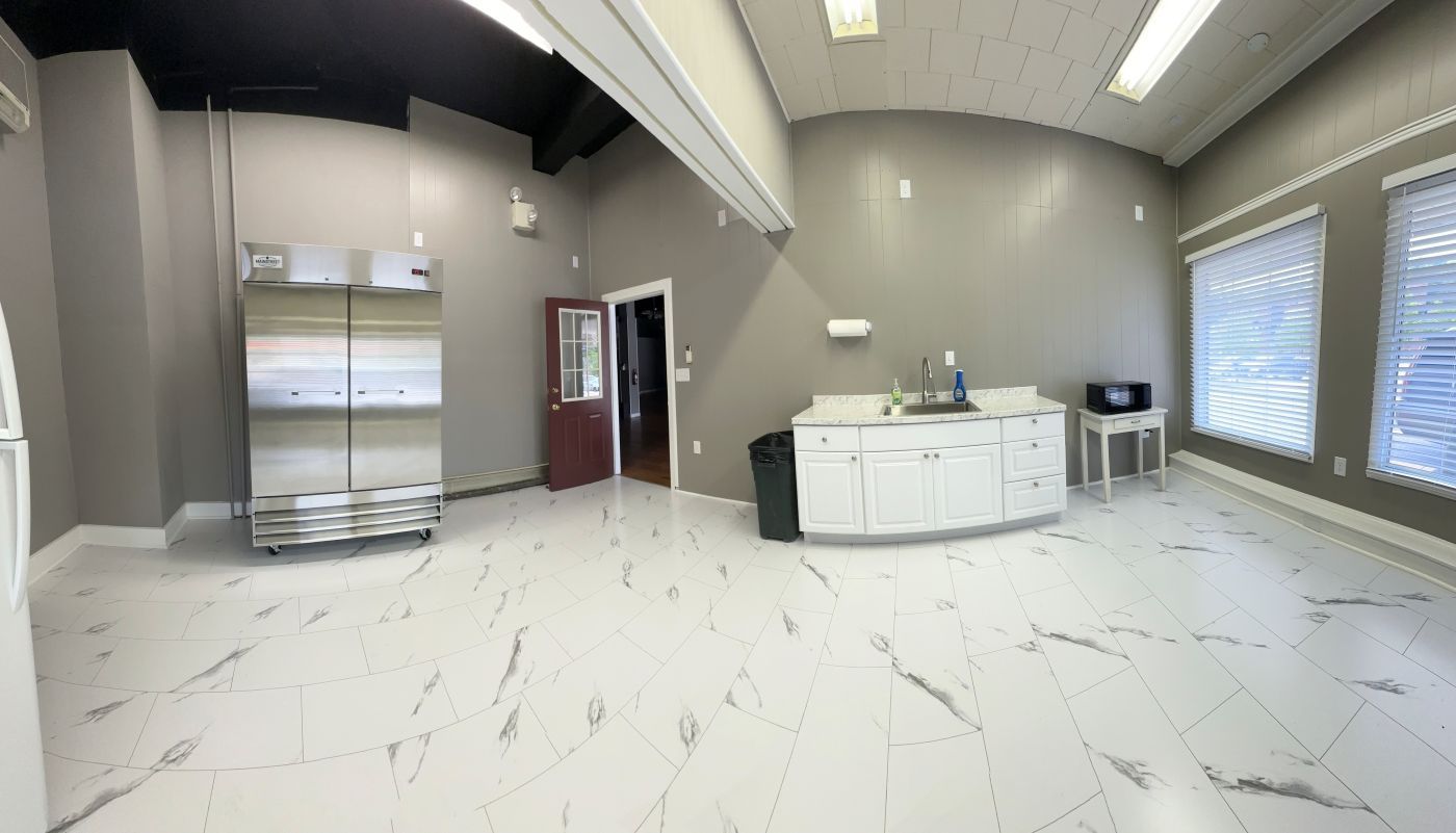 A large room with a white tile floor and a marble counter top.