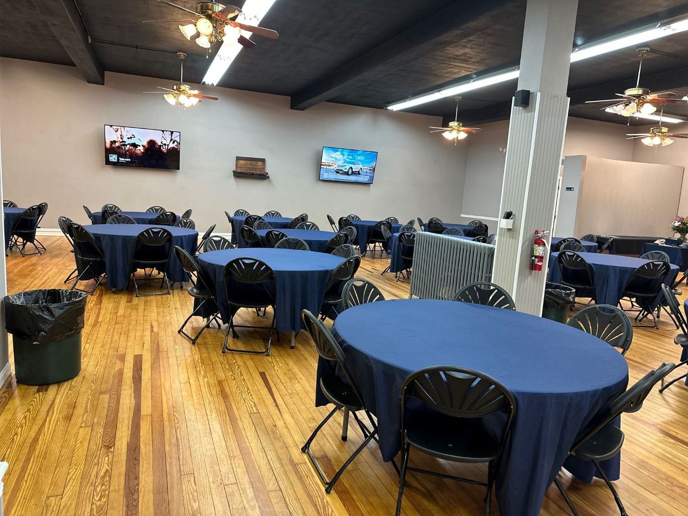 A large room with tables and chairs set up for a party.