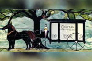 A stained glass painting of a horse drawn carriage with a tree in the background.