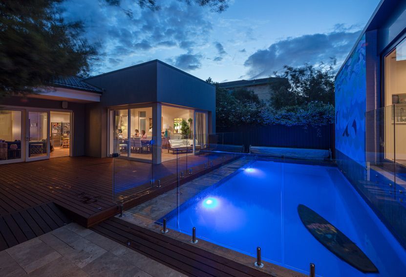 Backyard With Illuminated Pool, Deck, and Modern House at Dusk — Burmah Constructions In Kangaroo Valley, NSW