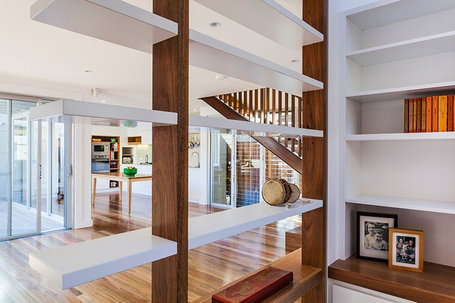 White Shelves on Brown Wood Supports Divide a Bright Room With a Staircase — Burmah Constructions In Kangaroo Valley, NSW