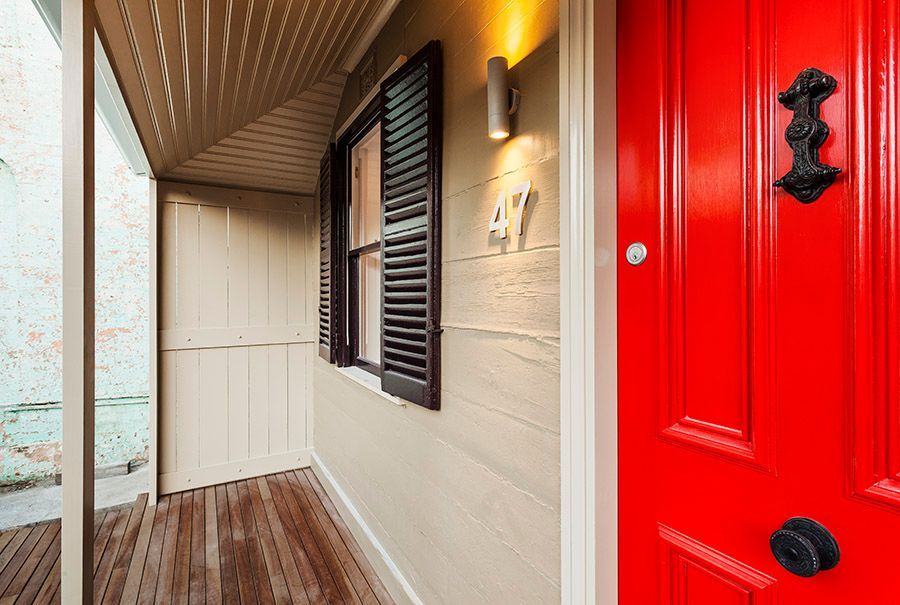Red Door With Black Hardware Next to Window With Shutters — Burmah Constructions In Kangaroo Valley, NSW