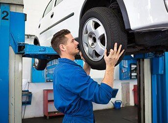 Mechanic Adjusting the Tire Wheel — Tires & Auto Repairs in San Antonio, TX