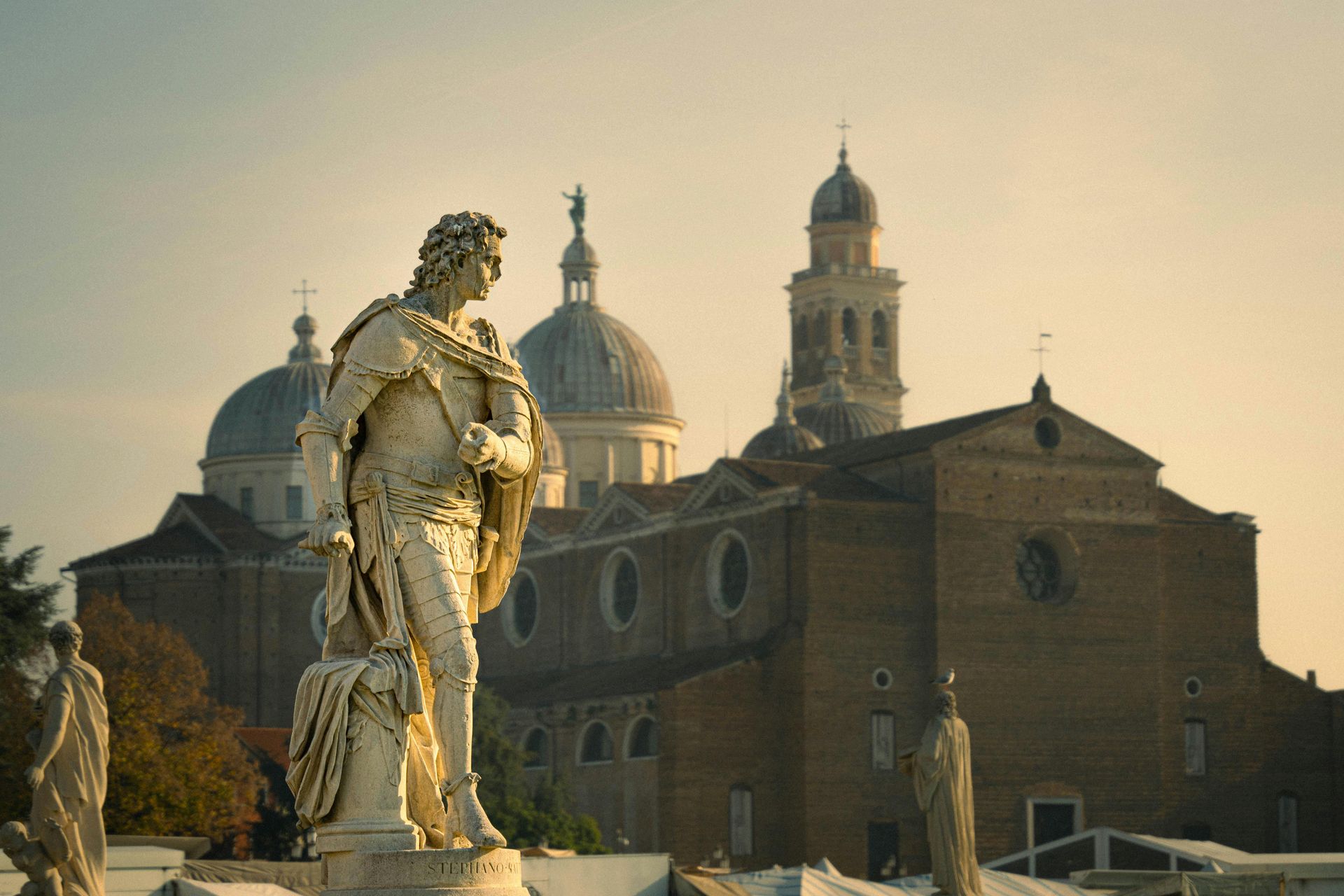 Foto di una statua a Padova in Prato della Valle, con sullo sfondo una chiesa e un campanile