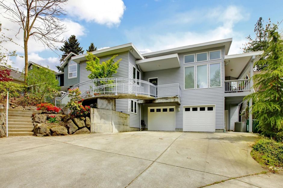 a house with a large concrete driveway and stairs