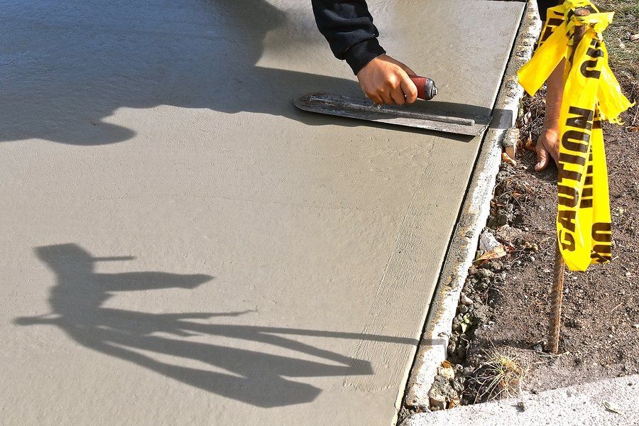 smoothing out a freshly poured concrete patio