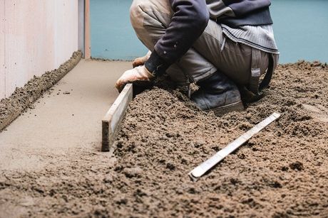 A worker smoothing out a concrete pour