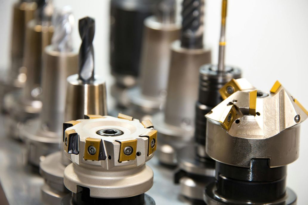 Metal cutting tools arranged on a surface, various shapes and sizes, close-up shot, metallic and gold details.