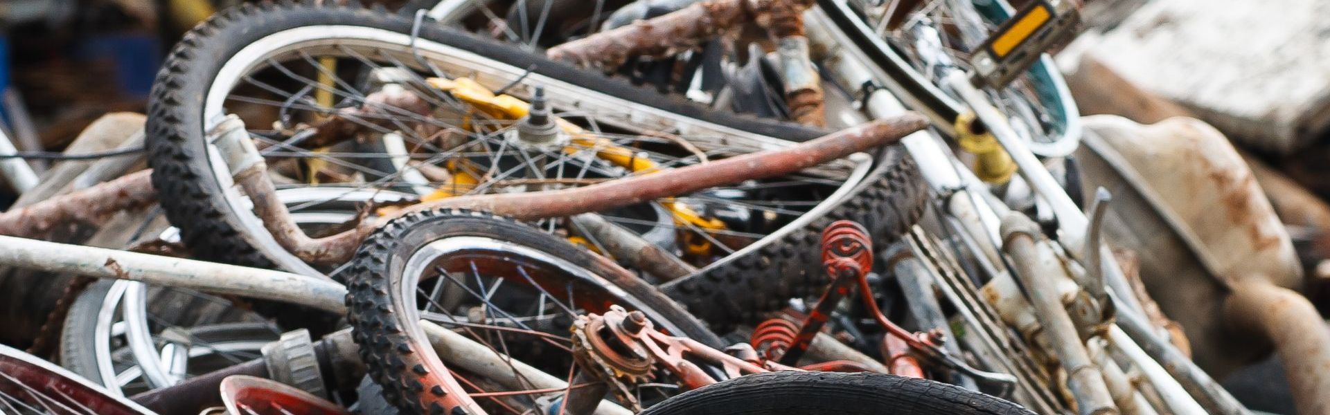 A pile of old bicycles sitting on top of each other.