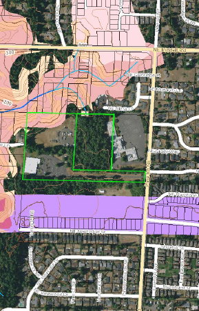 An aerial view of a residential area with a green square in the middle.
