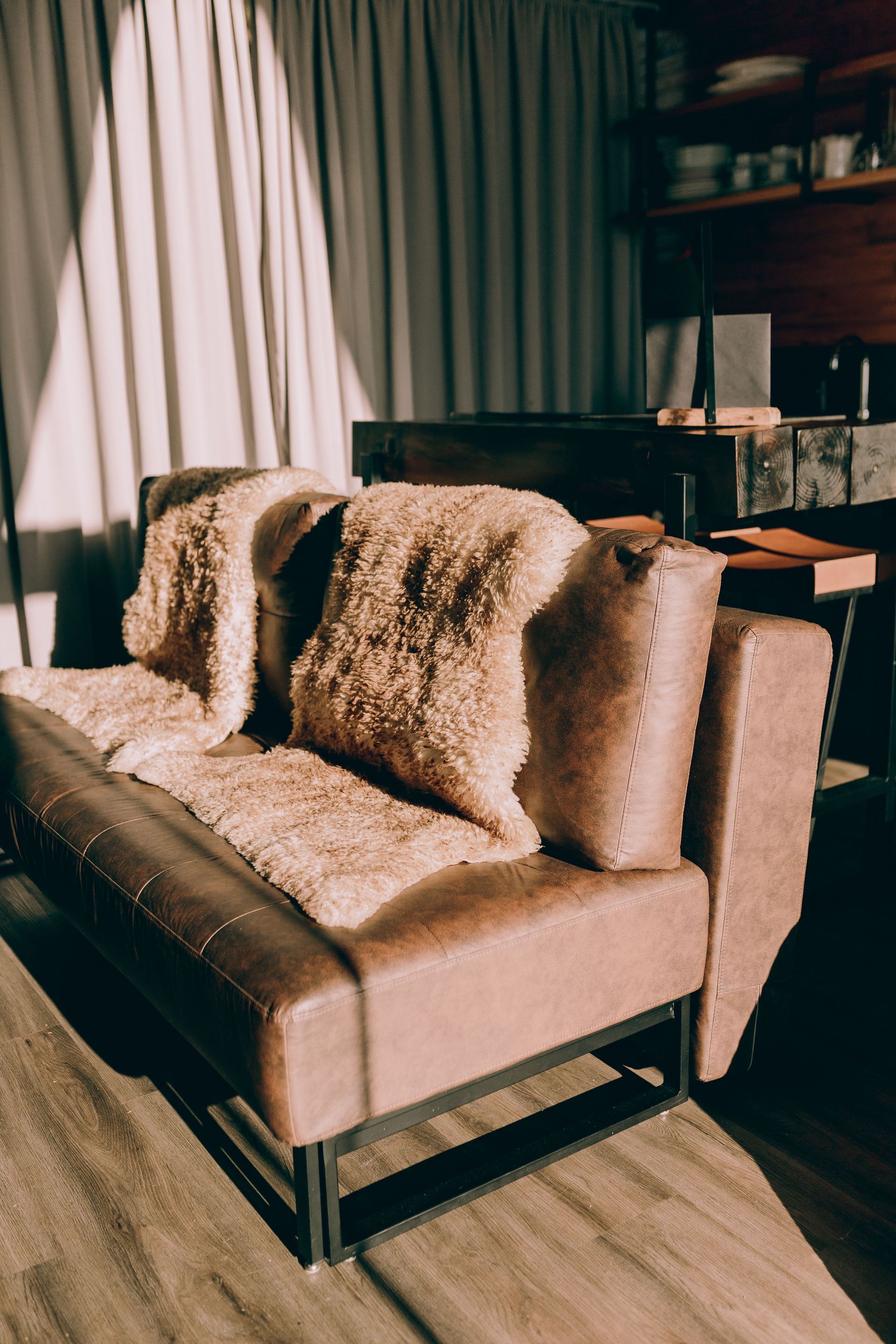 Beige sofa with a furry throw blanket in a sunlit living room