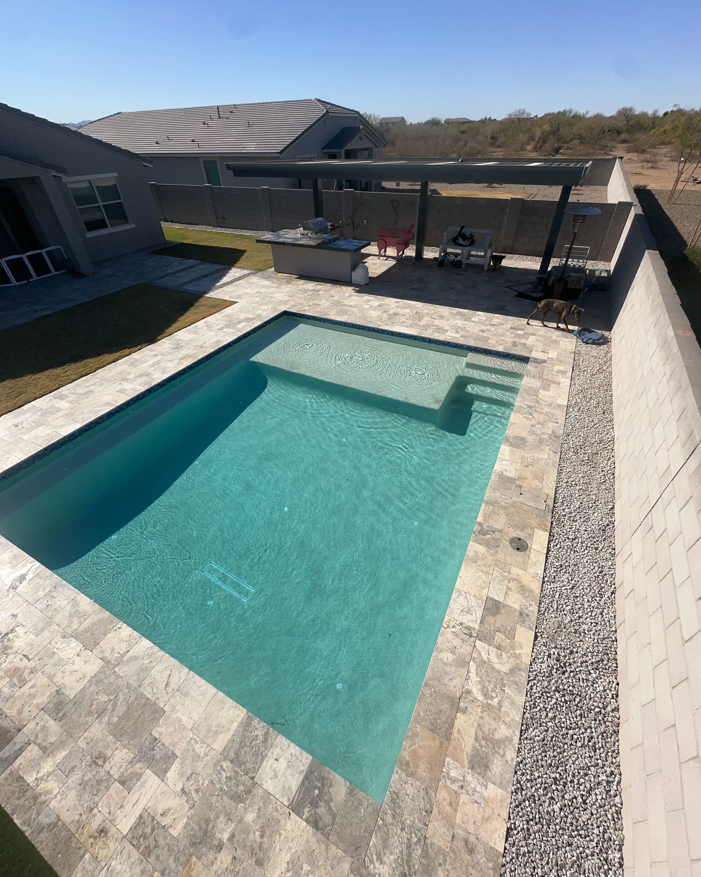 An aerial view of a swimming pool with a house in the background