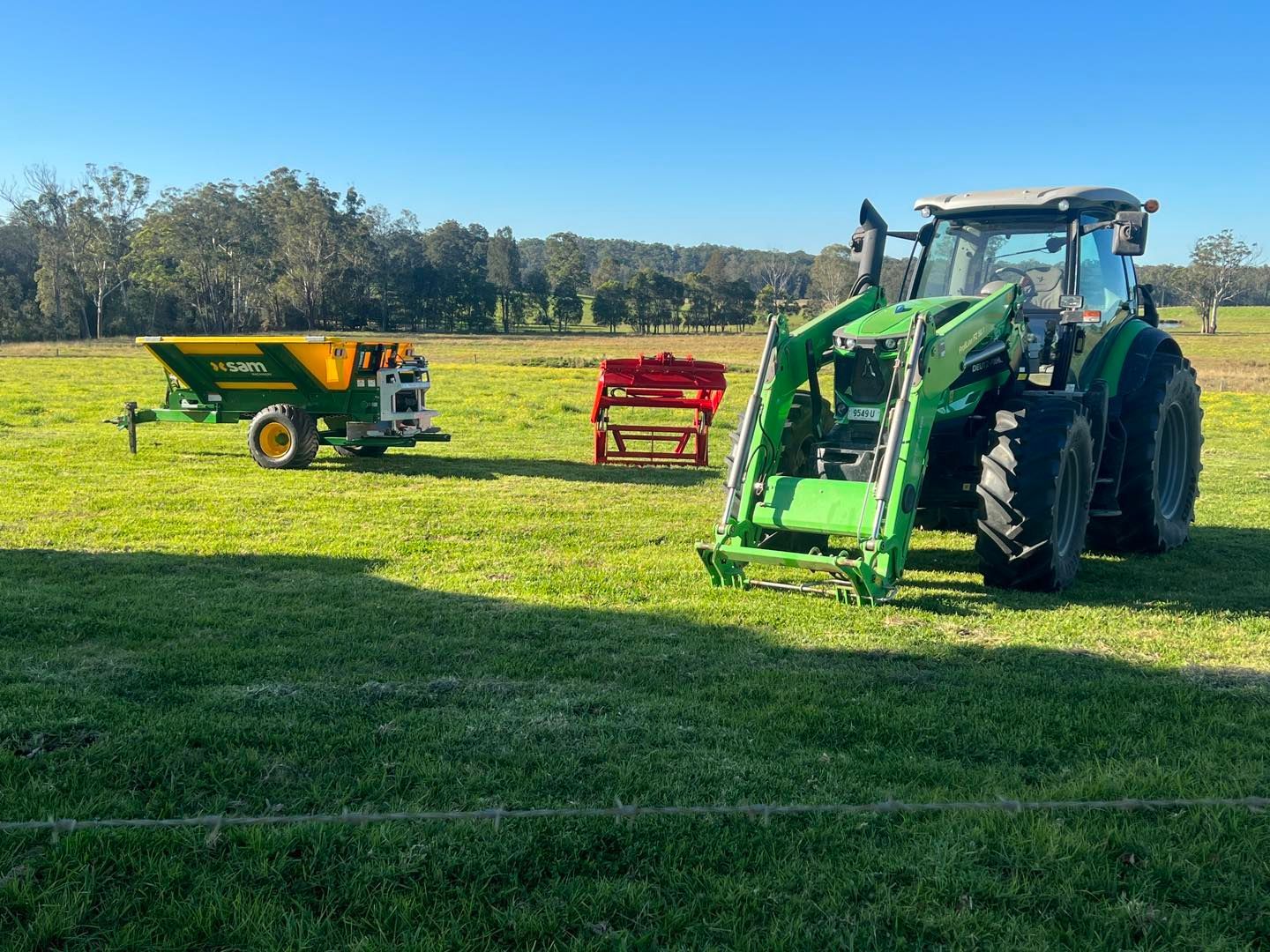 A Red Tractor Is Plowing a Field with A Plow — Thompson's Farm Gear In Kempsey, NSW