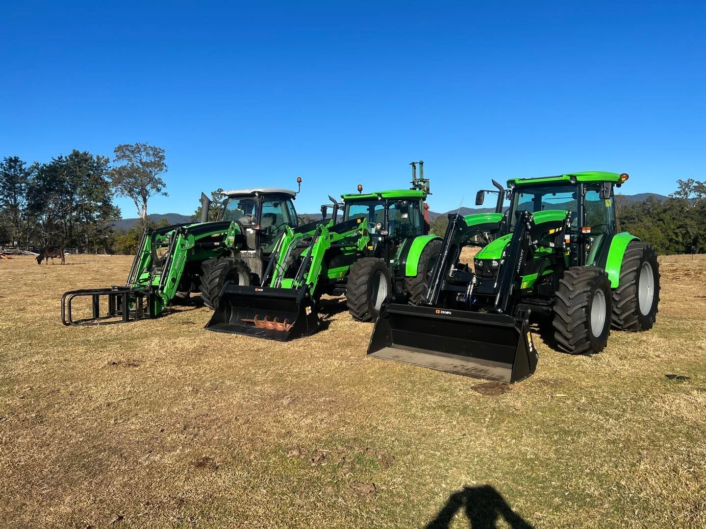 Two Tractors Are Parked in A Grassy Field — Thompson's Farm Gear In Kempsey, NSW