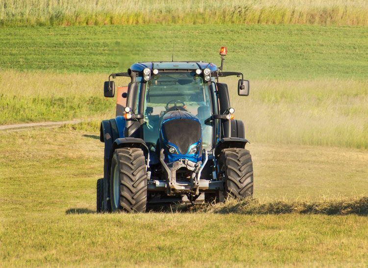 Blue Tractor Cutting Grass on the Farm — Thompson's Farm Gear In Kempsey, NSW