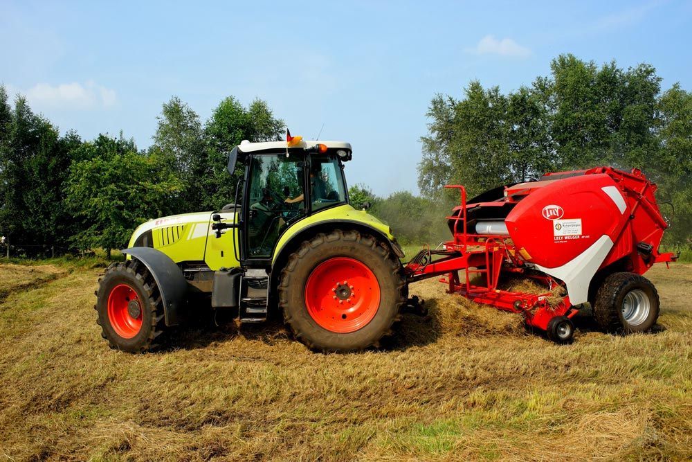 Hay Machinery Paired with Tractor in Action — Thompson's Farm Gear In Kempsey, NSW