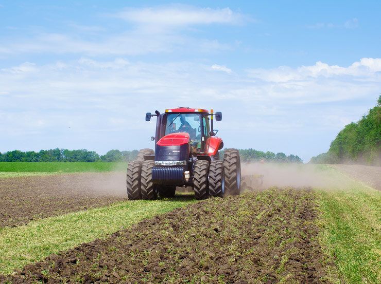 Tractor Amidst Expansive Agricultural Terrain — Thompson's Farm Gear In Coffs Harbour, NSW