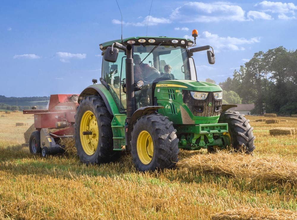 Green Tractor in a Brown Grass Field — Thompson's Farm Gear In Taree, NSW