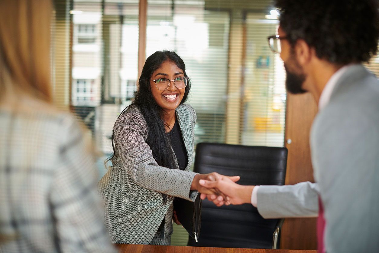 Image of woman shaking hands with male colleague at the beginning of an interview process