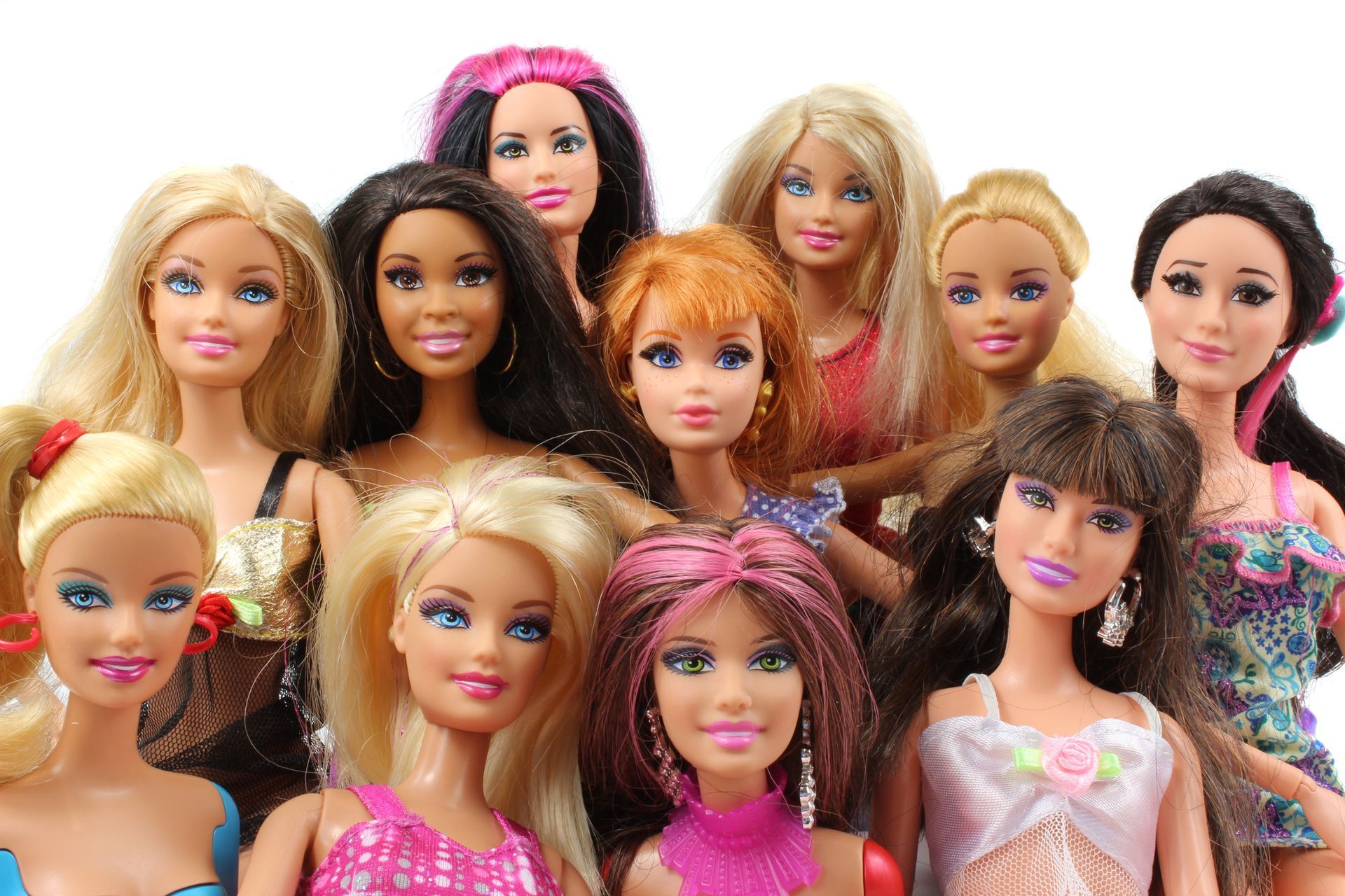 A group of Barbie dolls are standing next to each other