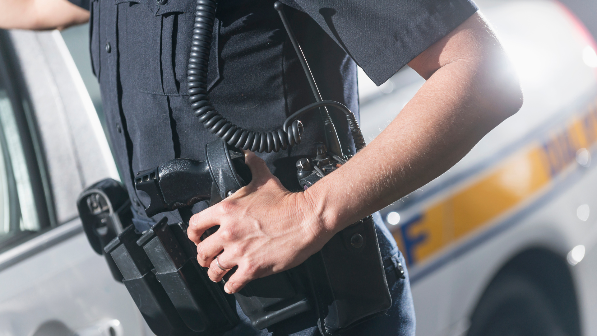 A security guard is standing in front of a parking lot.