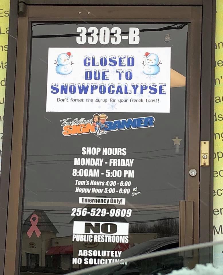 A store front with a sign that says closed due to snowpocalypse