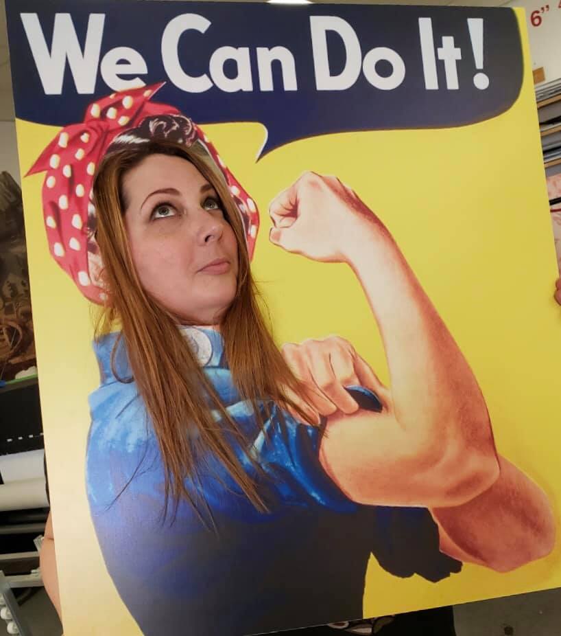 A woman is holding a sign that says we can do it