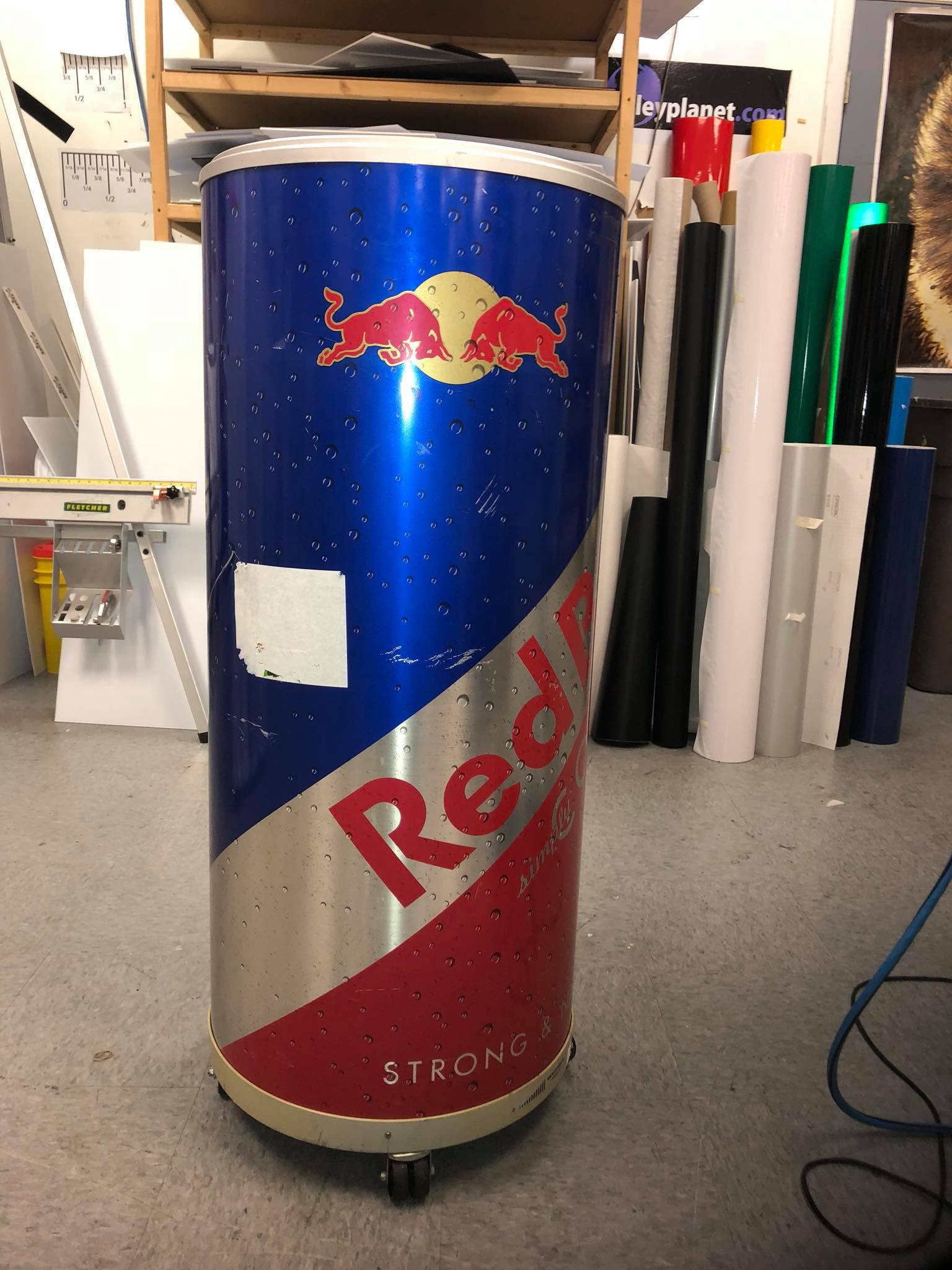 A red bull can is sitting on the floor in a room