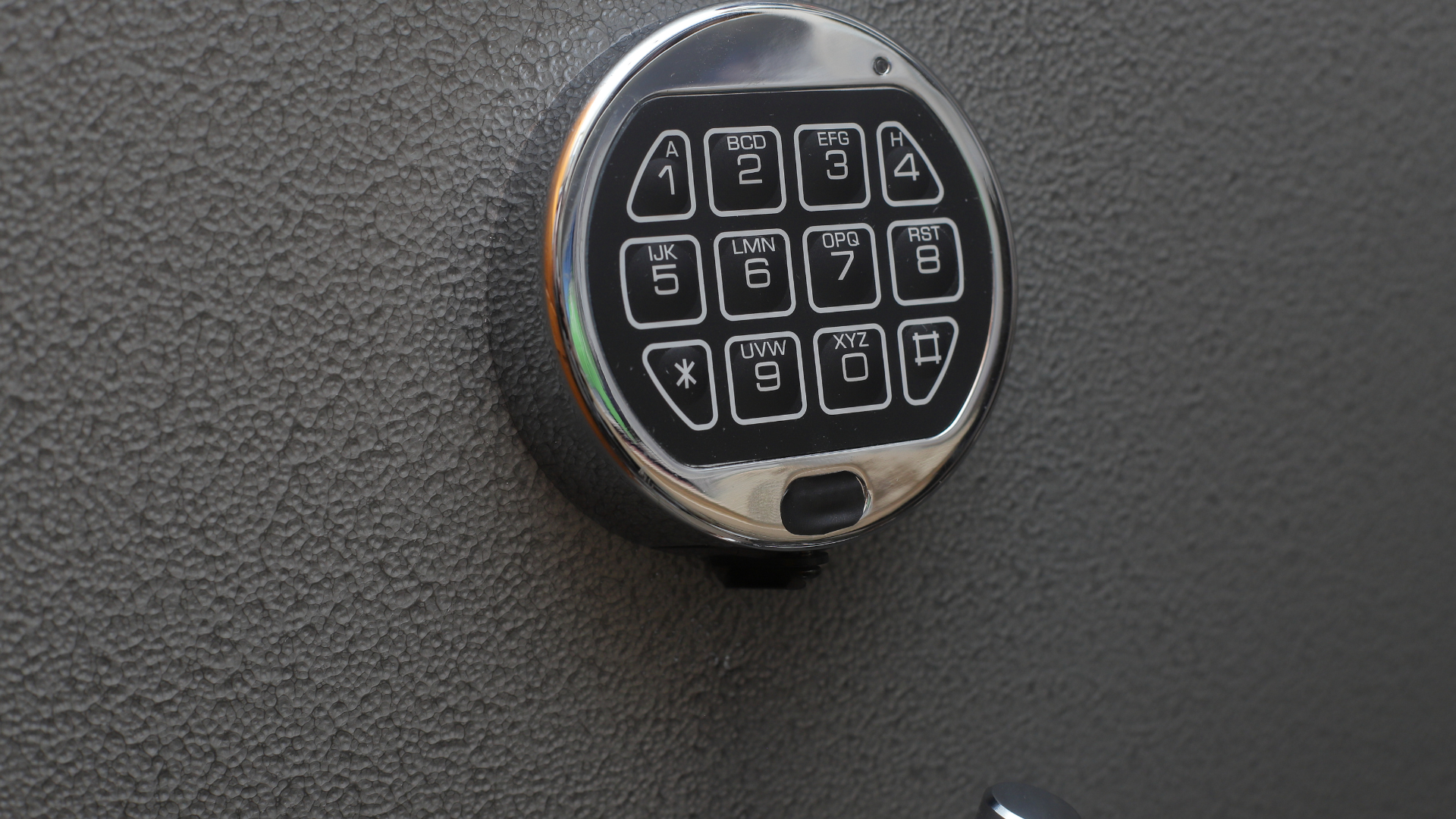 A close up of a keypad on a safe on a wall.