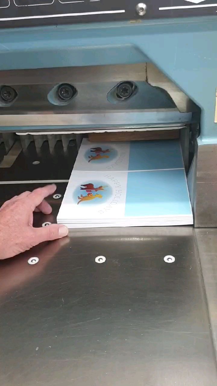 A Person is Holding a Piece of Paper in Front of a Machine — Brindabella Print In Woden, ACT