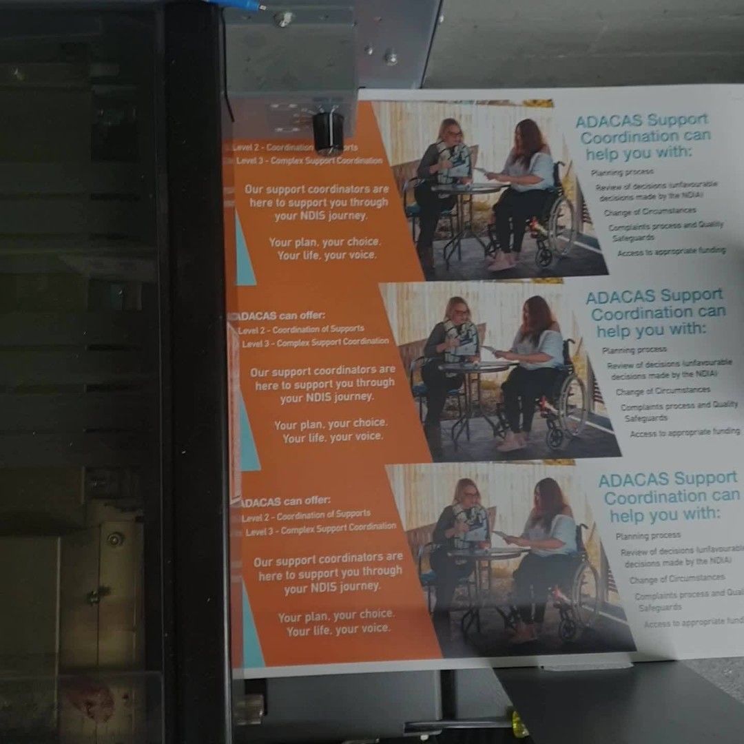 A Group of People Are Sitting at a Table With a Sign — Brindabella Print In Woden, ACT