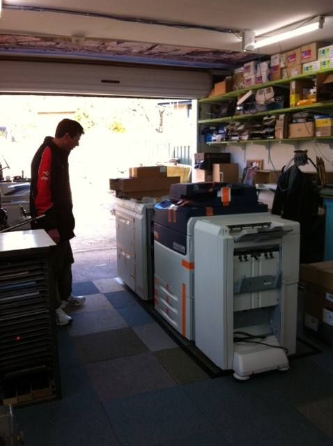 A Man Stands in Front of a Row of Printers — Brindabella Print In Belconnen, ACT