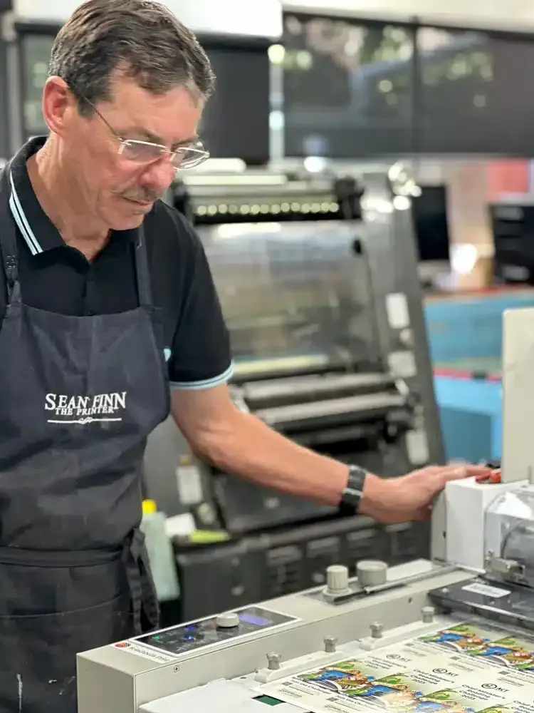 A Man is Working on a Machine in a Printing Shop — Brindabella Print In Pearce, ACT