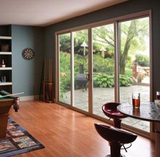 a living room with a pool table and sliding glass doors leading to a patio .