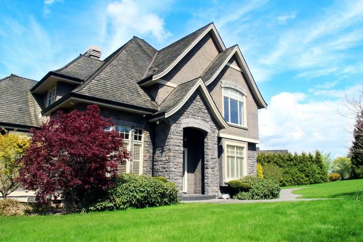 a large house with a lush green lawn in front of it